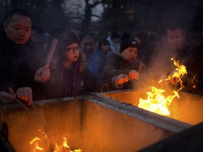 People light sticks of incense in a cauldron as they pray at the Lama Temple in Beijing, Tuesday, Feb. 5, 2019. Chinese people are celebrating the first day of the Lunar New Year on Tuesday, the Year of the Pig on the Chinese zodiac.