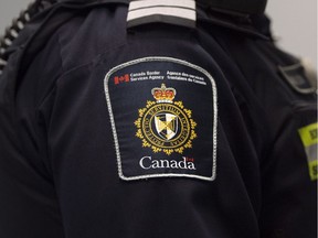 A Canadian Border Services agent stands watch at Pearson International Airport in Toronto, Ont. on Tuesday, December 8, 2015 where Syrian refugees will arrive later this week. THE CANADIAN PRESS/Darren Calabrese ORG XMIT: POS2015120815454805