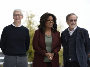 Apple Inc. CEO Tim Cook, Oprah Winfrey and filmmaker Steven Spielberg (left to right) pose for photos during an Apple product launch event at the Steve Jobs Theater at Apple Park on March 25, 2019 in Cupertino, Calif.