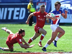 Pierre Mignot of France carries the ball against Isaac Kaay, left, and Luke McCloskey of Canada during the USA Sevens Rugby tournament at Sam Boyd Stadium on March 3 in Las Vegas.