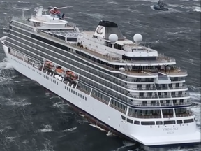 In this image taken from video made available by CHC helicopters, helicopters fly over the cruise ship Viking Sky after it sent out a Mayday signal because of engine failure in windy conditions off the west coast of Norway, Saturday March 23, 2019. (CHC helicopters via AP)