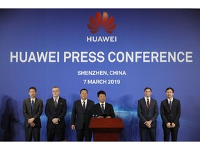 In this March 7, 2019, photo, Huawei Rotating Chairman Guo Ping, center, speaks in front of other executives during a press conference in Shenzhen city, China's Guangdong province. Chinese tech giant Huawei is launching a U.S. court challenge to a law that labels the company a security risk and would limit its access to the American market for telecom equipment.