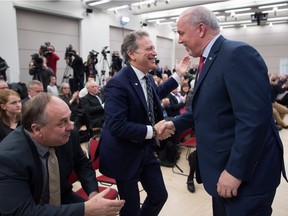 B.C. Minister of Environment and Climate Change Strategy George Heyman, centre, shakes hands with B.C. Premier John Horgan.