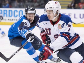 United States' Quinn Hughes (7) fights for control of the puck with Finland's Samuli Vainionpaa (12) during third period IIHF world junior hockey action in Victoria, Monday, Dec. 31, 2018. Quinn Hughes is expected to make his NHL debut with the Vancouver Canucks on Thursday. The 19-year-old defenceman has been in town for more than two weeks but a nagging ankle injury kept him from taking part in a full practice with his new teammates until Wednesday.