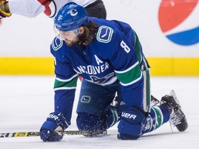 Vancouver Canucks' Chris Tanev kneels on the ice after blocking a shot during the first period of an NHL hockey game against the New Jersey Devils in Vancouver on Friday night. Travis Green said post-game Tanev's season is over because of a suspected fracture in his foot.