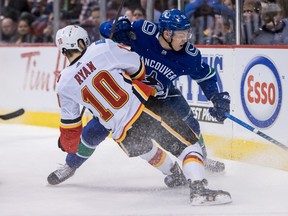 Vancouver Canucks' Troy Stetcher checks Calgary Flames' Derek Ryan during first period NHL hockey action in Vancouver on Saturday, March 23, 2019.