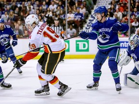 Calgary Flames' Matthew Tkachuk (19) is hooked by Vancouver Canucks' Elias Pettersson (40) during third period NHL hockey action in Vancouver on Saturday, March 23, 2019.