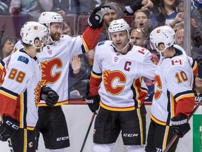 Calgary Flames' Mark Giordano (5) celebrates his goal with teammates during first period NHL hockey action against the Vancouver Canucks, in Vancouver on Saturday, March 23, 2019.