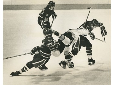 Brian Shettler of Winnipeg Warriors sends John Neeld of New Westinster Bruins into orbit. Photo by Mark Van Manen, Sun Photo. Ran November 13 1980 [PNG Merlin Archive]