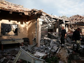 Police officers inspect the damage to a house hit by a rocket in Mishmeret, central Israel, Monday, March 25, 2019. An early morning rocket from the Gaza Strip struck a house in central Israel on Monday, wounding six people, including one moderately, an Israeli rescue service said, in an eruption of violence that could set off another round of violence shortly before the Israeli election.
