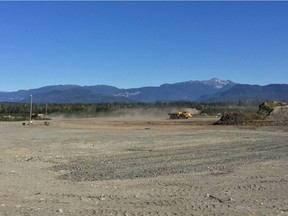 Heavy equipment operators move material  at a LNG Canada construction site in Kitimat.