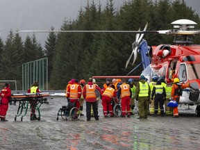 Passengers are helped from a rescue helicopter in Fraena, Norway, Sunday March 24, 2019, after being rescued from the Viking Sky cruise ship. Rescue workers are evacuating more passengers from a cruise ship that had engine problems in bad weather off Norway's western coast while authorities prepare to tow the vessel to a nearby port.