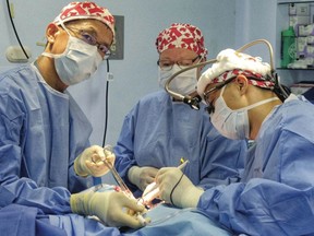 Family doctor Anthony Yue, left, and nurse Gerry Schauffer assist surgeon Roy Cheung at the Hospital de San Pedro in Antigua, Guatemala.