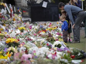 Mourners lay flowers on a wall at the Botanical Gardens in Christchurch, New Zealand, on Monday, March 18, 2019. A steady stream of mourners paid tribute at makeshift memorial to the 50 people slain by a gunman at two mosques in Christchurch on Friday.
