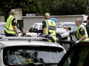 Ambulance staff take a man from outside a mosque in central Christchurch, New Zealand, Friday, March 15, 2019. A witness says many people have been killed in a mass shooting at a mosque in the New Zealand city of Christchurch.