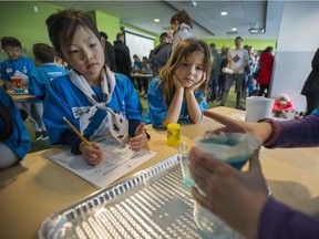 Zoe Siu Narlin and Baela Irving watch Bethany Duffield perform a permeability experiment at the Science Games at the Telus World of Science in Vancouver on Saturday. More than 150 children from across B.C. participated in the Science Games