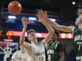 Cameron Slaymaker of the Terry Fox Ravens battles for a loose ball with Oak Bay's Ewan Mackenzie during Thursday's second-round action in the Quad-A B.C. boys' provincial basketball championship tournament at Langley Events Centre. The Ravens won and move on to Friday's semifinals.