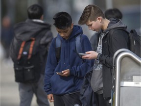 Riverside Secondary School students Brad Lall, centre, and Grady Minor, right, use their smartphones after school Tuesday in Port Coquitlam. Teachers in B.C. are embracing smartphones as a teaching tool to add theatricality and reduce drudgery in the classroom.