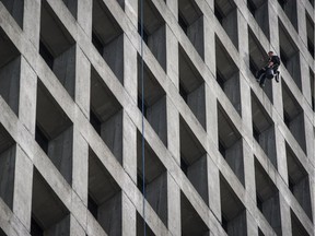 A window washer dangles outside office tower at 1075 West Georgia in Vancouver in this 2016 file photo.