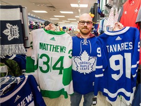 Joel Herder, originally from Toronto but who now lives in Courtney, holds up Auston Matthews and John Tavares Toronto Maple Leafs jerseys inside Vancity Sports in Vancouver on Wednesday.