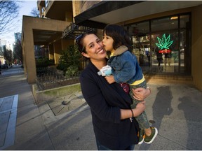 Ritu Vinluan with three-year-old son Samir in front of the Weeds cannabis store on Helmcken street in Vancouver.