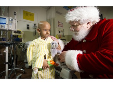 Surrey  B.C.:  December 20, 2016 Making their day special "Santa Claus"  brightened the day for many paying an  early visit to the Surrey Memorial Hospital Pediatric Unit  on December 20th. Here young cancer patient Jithu Srikanth gets some words from Santa.   The jolly man made his appearance  by Helicopter landing on the roof of the hospital in style.   Mark van Manen/ PNG Staff  photographer   see  ***Main for *** Jenn Saltman Vancouver Sun/Province  News    / [PNG Merlin Archive]