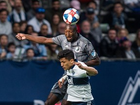 Minnesota United's Romain Metanire (19) heads the ball near Vancouver Whitecaps' Fredy Montero (12) during the first half MLS soccer action in Vancouver on Saturday, March 2, 2019.