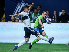 Seattle Sounders' Brad Smith (11) kicks the ball near Vancouver Whitecaps' Jake Nerwinski (28) during the first half MLS soccer action in Vancouver, B.C., on Saturday March 30, 2019.