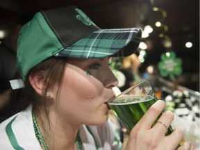 A reveller sips a green beer at the St. Patrick's Day party at the Blarney Stone on March 17, 2018.