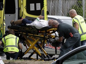 Ambulance staff take a man from outside a mosque in central Christchurch, New Zealand, Friday, March 15, 2019. A witness says many people have been killed in a mass shooting at a mosque in the New Zealand city of Christchurch.