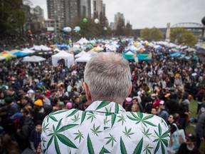 A man wearing a jacket covered with marijuana leaves looks out over the crowd during the 4-20 annual marijuana celebration, in Vancouver, B.C., on Friday April 20, 2018.