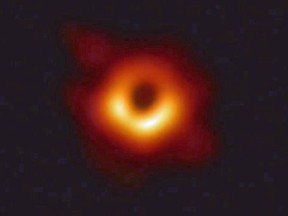 A handout photo released on April 10, 2019 shows the first photograph of a black hole and its fiery halo, released by Event Horizon Telescope astronomers.