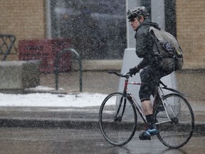 A cyclist makes his way through the falling snow along Jasper Avenue near 101 Street on a recent April day.