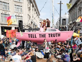 Climate change activists listen to speeches at their encampment blocking the road junction at Oxford Circus in the busy shopping district in central London on April 18, 2019, during the fourth day of an environmental protest by the Extinction Rebellion group.