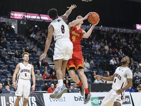 Calgary Dinos' Andrew Milner, second from right, leaps to put up a shot in front of Saint Mary's Huskies' Nevell Provo during the second half of quarterfinal action in the USports men's basketball national championship in Halifax on Friday, March 8, 2019. Members of the University of Calgary men's basketball team are mourning the loss of teammate Andrew Milner after his body was found in Moyie Lake in southeastern British Columbia.