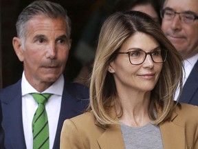 In this April 3 file photo, actress Lori Loughlin, front, and husband, clothing designer Mossimo Giannulli, left, depart U.S. Federal Court in Boston after facing charges in a nationwide college-admissions bribery scandal.