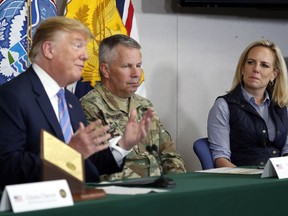 Lt. Gen. Todd Semonite, commanding General of the U.S. Army corps of Engineers , center and Homeland Security Secretary Kirstjen Nielsen, listens as President Donald Trump participates in a roundtable on immigration and border security at the U.S. Border Patrol Calexico Station in Calexico, Calif., Friday April 5, 2019. Trump headed to the border with Mexico to make a renewed push for border security as a central campaign issue for his 2020 re-election.