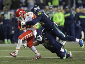 Kansas City Chiefs quarterback Patrick Mahomes (15) is tackled by Seattle Seahawks defensive end Frank Clark, right, during the second half of an NFL football game, Sunday, Dec. 23, 2018, in Seattle.