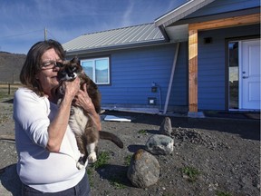 Ester Spye, with her cat Socks, in front of her new home. She lost her house in the 2017 wildfire. Socks was missing for 52 days after the house burned down. Allen Douglas for PNG [PNG Merlin Archive]