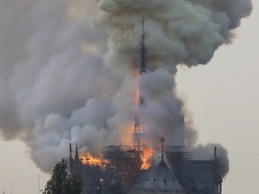 Flames and smoke are seen billowing from the roof at Notre-Dame Cathedral in Paris on April 15, 2019. - A fire broke out at the landmark Notre-Dame Cathedral in central Paris, potentially involving renovation works being carried out at the site, the fire service said.