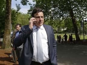 Francesco Aquilini, owner of the Vancouver Canucks NHL hockey team, talks on a phone in Seattle following a news conference, Wednesday, June 7, 2017.