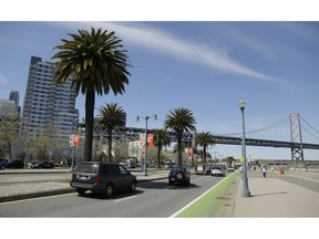 In this photo taken Thursday, April 18, 2019, cars make their way along the Embarcadero, with the San Francisco-Oakland Bay Bridge in the background, across the street from the proposed site of a homeless shelter in San Francisco. The city of San Francisco, which has too little housing and too many homeless people sleeping in the streets, is teeming with anxiety and vitriol these days. A large new homeless shelter is on track to go up along a scenic waterfront area dotted with high-rise luxury condos, prompting outrage from some residents.