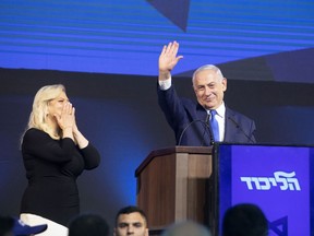 Israeli Prime Minister Benjamin Netanyahu waves as wife Sara Netanyahu reacts at the Likud party headquarters in Tel Aviv, Israel, early on April 10, 2019. MUST CREDIT: Bloomberg photo by Kobi Wolf.