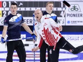 Canada skip Kevin Koe reacts to his shot as Scotland lead Hammy McMillan, left, and second Bobby Lammie look on during the qualification games at the Men's World Curling Championship in Lethbridge, Alta. on Saturday, April 6, 2019.