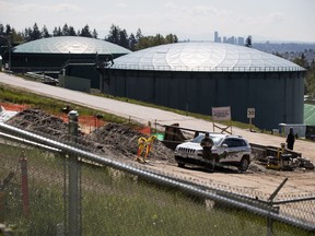 A security guard stands nearby construction workers at the Kinder Morgan Burnaby Terminal tank farm, the terminus point of the Trans Mountain pipeline, in Burnaby, B.C., on Tuesday April 30, 2019.