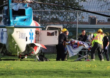 A woman is taken to a Air Ambulance as first responders attend the scene of a deck collapse in Langley, B.C. on Friday April 19, 2019.
