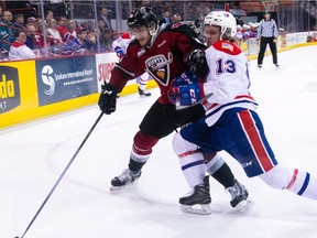 Milos Roman of the Vancouver Giants battles with Riley Woods of the Spokane Chiefs during Wednesday's Western Hockey League playoff action in Spokane. The Giants won 4-3 in overtime to take a 3-1 lead in their best-of-seven WHL Western Conference Final series.