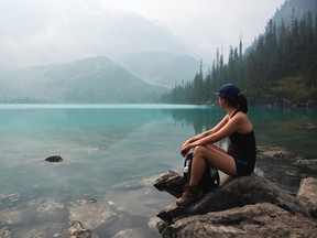 A woman looks out onto the water at Joffre Lakes Provincial Park.