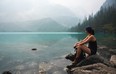 A woman looks out onto the water at Joffre Lakes Provincial Park.