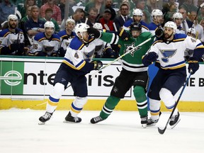 Dallas Stars' Jason Spezza, center, squeezes between St. Louis Blues' Carl Gunnarsson (4), of Sweden, and Robert Bortuzzo while chasing the puck during the first period in Game 3 of an NHL second-round hockey playoff series, Monday, April 29, 2019, in Dallas.